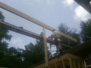 Carpenter setting a ridge beam over a new addition frame — Ice Dam Removal by Roofing Brothers in Rollins