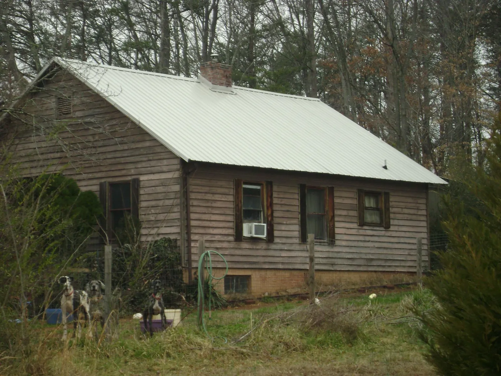White metal roof on an old wood sided farmhouse, from a Metal Roof Installation job in Rollins
